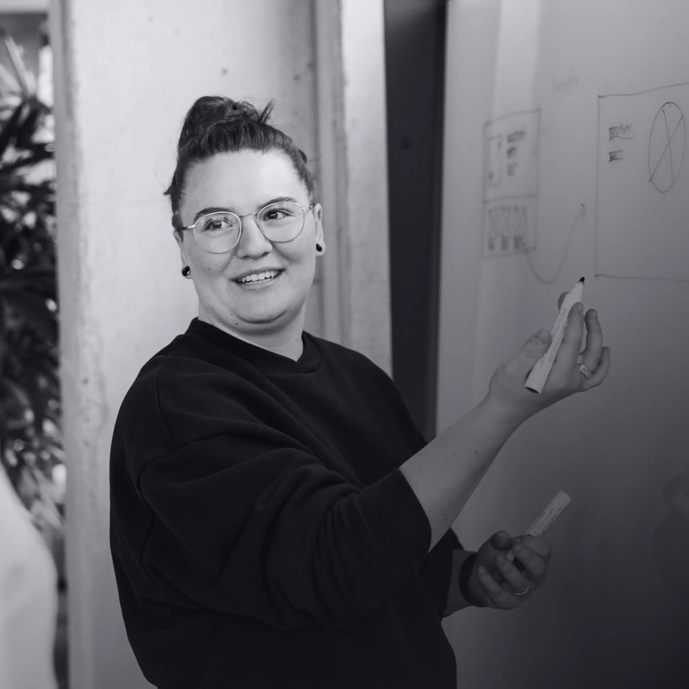 Flora Maxwell, UI Designerin zeichnet Wireframe am Whiteboard